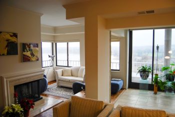 Neutral-toned living room with hardwood flooring and lots of windows.