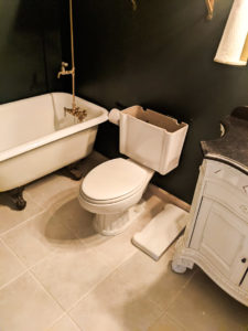 Bathroom renovation with a white clawfoot bathtub and antique-looking vanity.