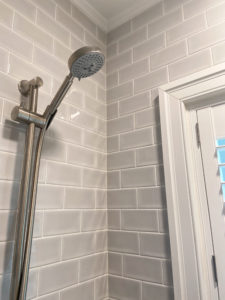 A new detachable showerhead in a tile shower.