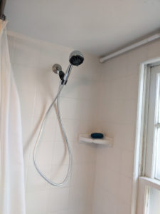 Inside of old shower tub combo; view of showerhead.