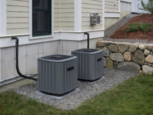 Two newly installed outdoor AC units beside a home.