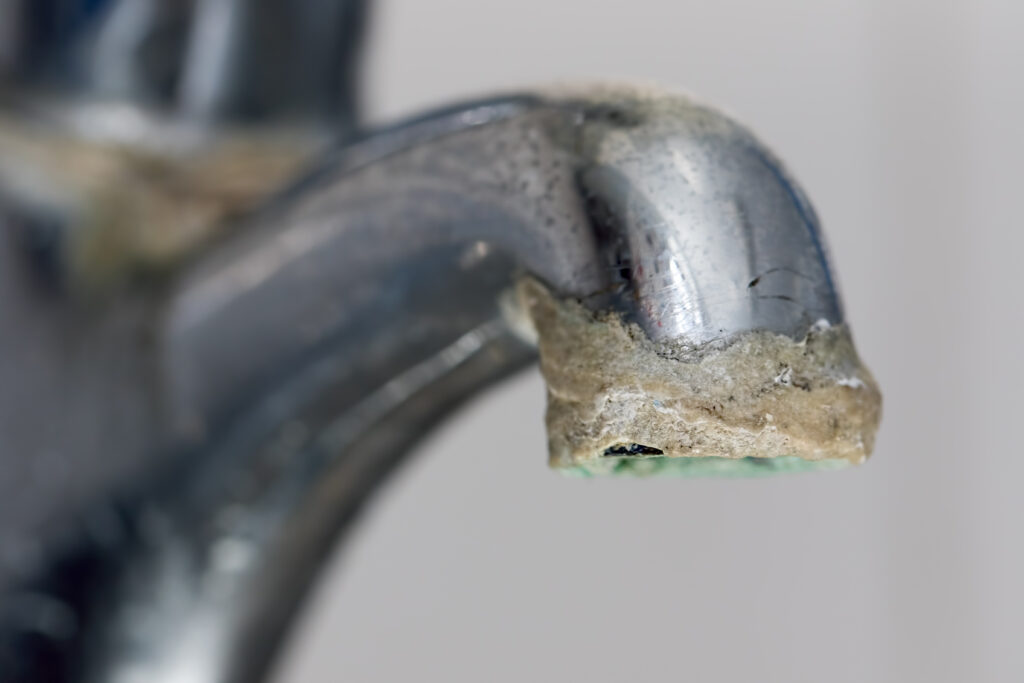 Mineral buildup from hard water on bathroom sink faucet